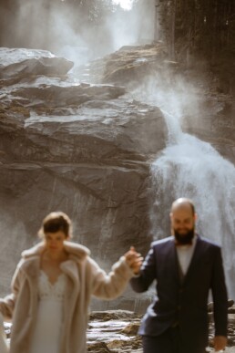 Wedding couple walking in front of a huge waterfall in Austria. Simon Leclercq fotograaf trouwfotograaf Leuven België Belgium Louvain photography destination wedding photography op locatie